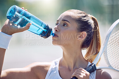 Buy stock photo Health, fitness and water, a woman tennis player on a break, drinking from a plastic bottle during a match on the court. Beautiful young lady playing sports, training for a healthy summer lifestyle.