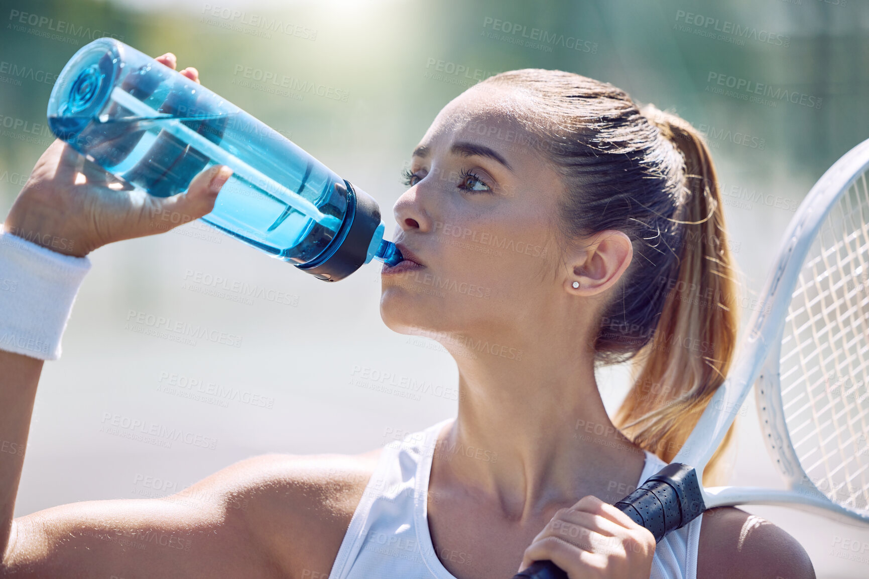 Buy stock photo Health, fitness and water, a woman tennis player on a break, drinking from a plastic bottle during a match on the court. Beautiful young lady playing sports, training for a healthy summer lifestyle.