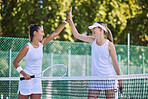 High five between female tennis players before a match or training outdoors on the court. Active, athletic and fit athletes playing are happy in a friendly sports competition or game