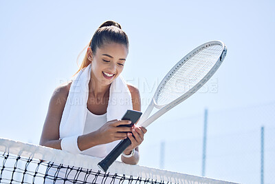 Buy stock photo Active, fit and happy female tennis player browsing social media on her phone outdoors on the court. A young female athlete or sportswoman posting her sport training online or on the internet