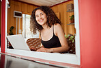 Lady working on a laptop while looking out the window of her modern, trendy and edgy house. Smiling, positive and young female student with an afro browsing on technology while thinking and learning 