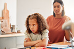 Unhappy, moody and angry little girl standing with arms crossed and looking upset while ignoring her mom. Upset daughter being scolded and reprimanded by her angry and disappointed mother at home