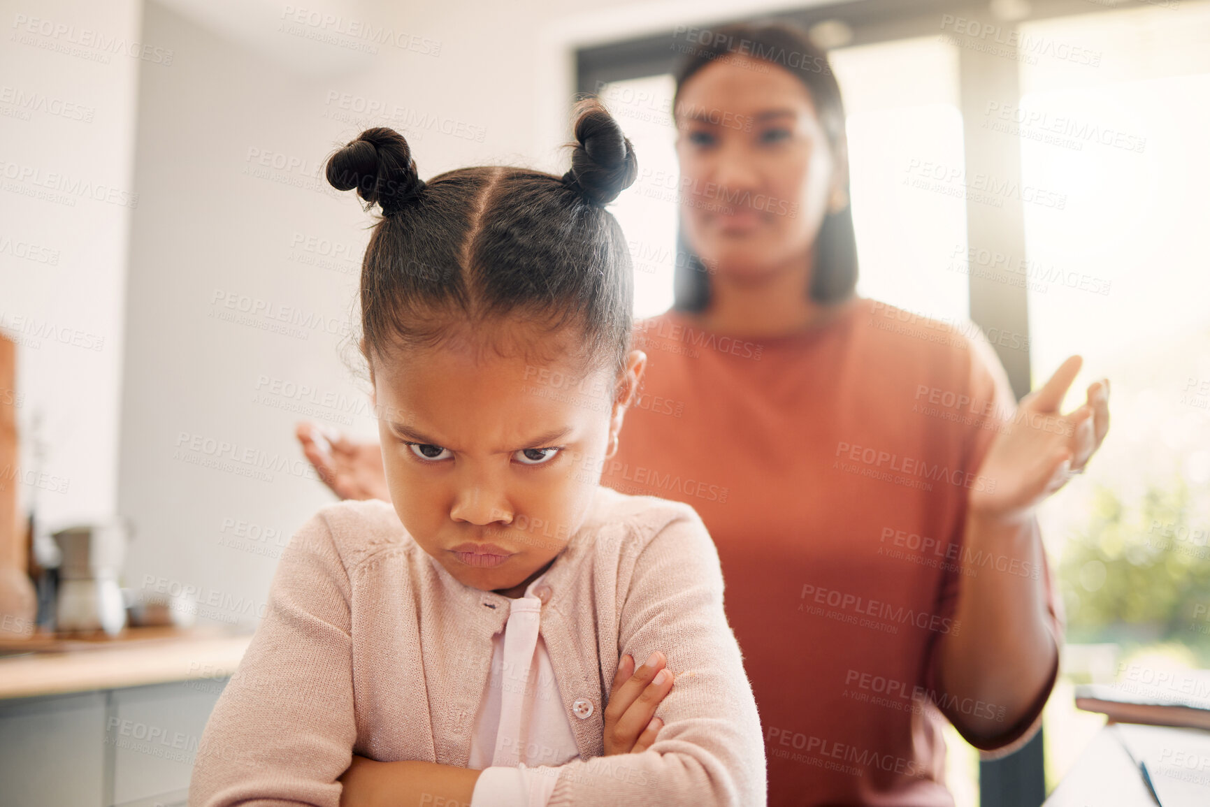 Buy stock photo Angry little girl, unhappy and upset after fight or being scolded by mother, frowning with attitude and arms crossed. Naughty child looking offended with stressed single parent in background.