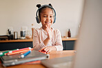 Distance learning, education and virtual student child on a video call lesson with a headset and laptop doing hello or bye greeting gesture. Little girl in an online classroom, homeschooling at home