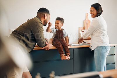 Buy stock photo Parents, child and home of a fun, loving and caring family being playful with their son. Funny father making silly faces with his boy while having a laugh together with his wife in a kitchen.