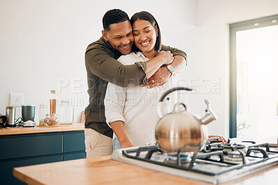 Buy stock photo Romantic, love and bonding couple hugging while enjoying quality time together at home. Loving husband showing affection, care and embrace to his relaxing wife while making tea in the kitchen