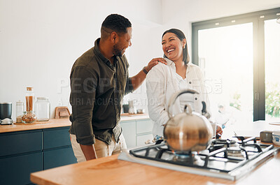 Buy stock photo Joyful and loving couple bonding and having fun while spending time together in the kitchen. Smiling, in love and carefree couple laughing, sharing a romantic moment while enjoying the morning