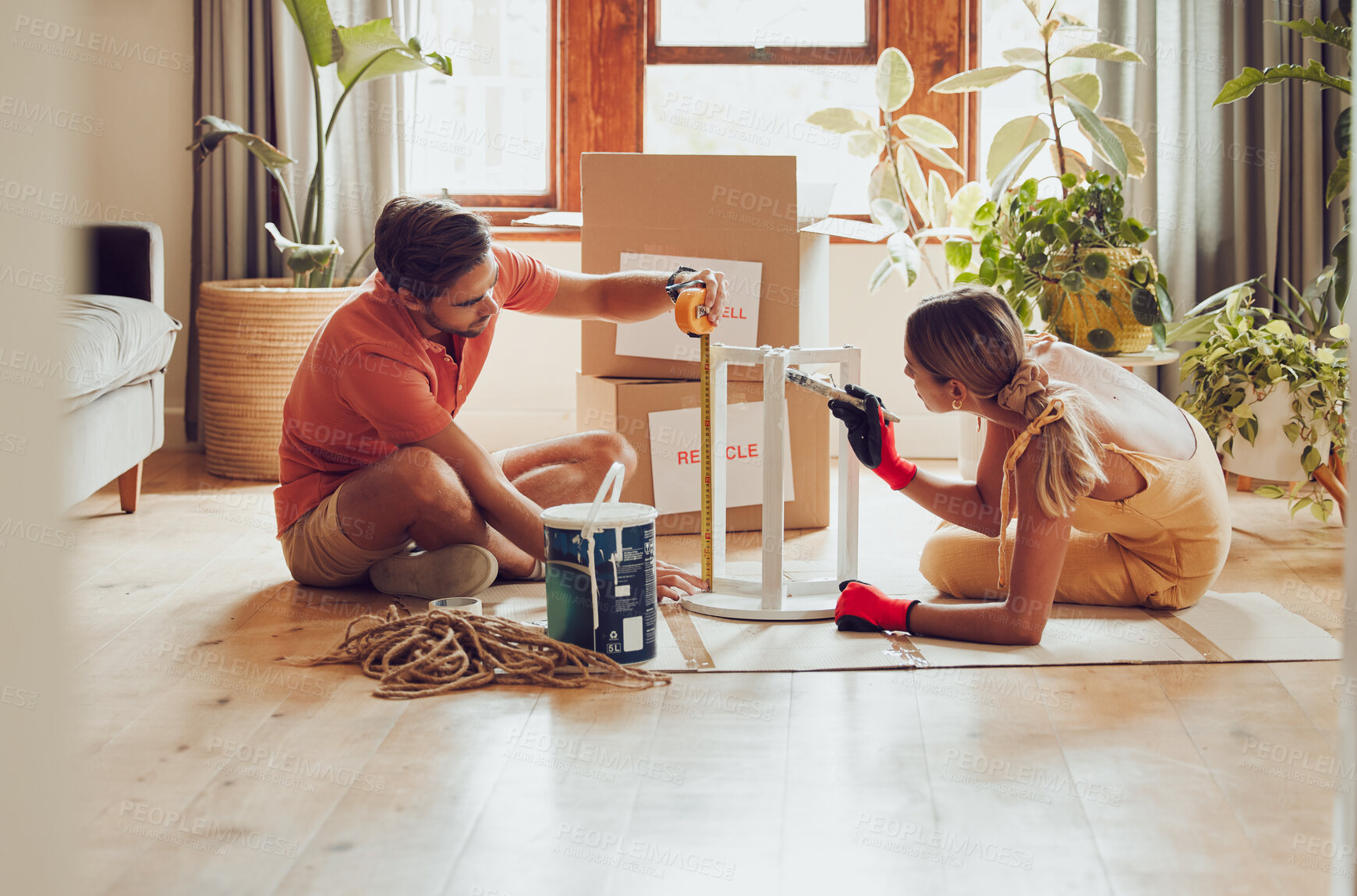 Buy stock photo Couple painting wooden table by recycle, donate and thrift furniture for a new home improvement project in new apartment. Creative and DIY man and woman with reusable objects, decorating their house