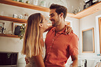 A lovely romantic moment by couple, smiling and in love looking into each others eyes in kitchen. Man and woman spending affectionate free time together, happy and bonding with embraced happiness. 