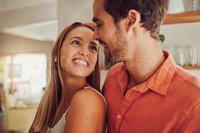 Buy stock photo Couple, smiling and in love having a lovely romantic moment in the kitchen at home. Man and woman spending affectionate free time together, happy and bonding with embraced happiness.