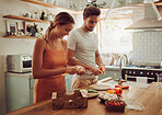 Cooking, happy and loving couple preparing a healthy meal in the kitchen together at home. Excited, carefree and joyful lovers doing smiling and laughing while making food or dinner