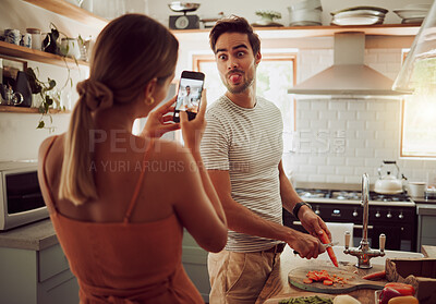 Buy stock photo Cooking man sticking out tongue to make silly, goofy and funny face to pose for a photo while making food in the kitchen at home. Crazy, fun and happy couple enjoying a playful moment while bonding