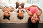 Kids laying upside down on bed enjoy playing and having fun together in parents bedroom. African American children or siblings bonding and enjoying childhood at cozy, warm and comfortable family home