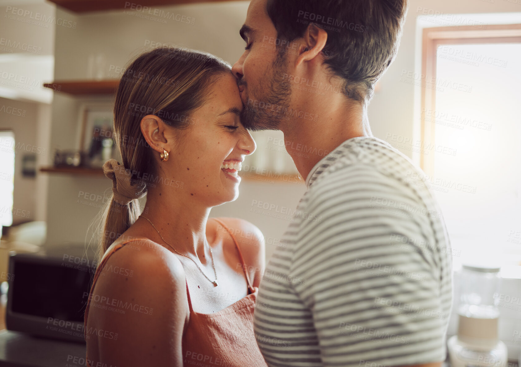 Buy stock photo Affectionate, loving and romantic couple in a happy relationship together in the kitchen at home. Man and woman sharing a moment of happiness, romance and bonding with each other in love. 