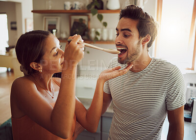 Buy stock photo Fun, bonding and a couple cooking in a kitchen at home, enjoying free time on weekend. Young girlfriend and boyfriend learning to cook together while being playful, having fun with their relationship