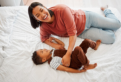 Buy stock photo Mother playing, bonding and laughing with her son playful, fun and funny moments together on the bed at home. Parenting and enjoying quality, happy single mom and her child in kids bedroom. 