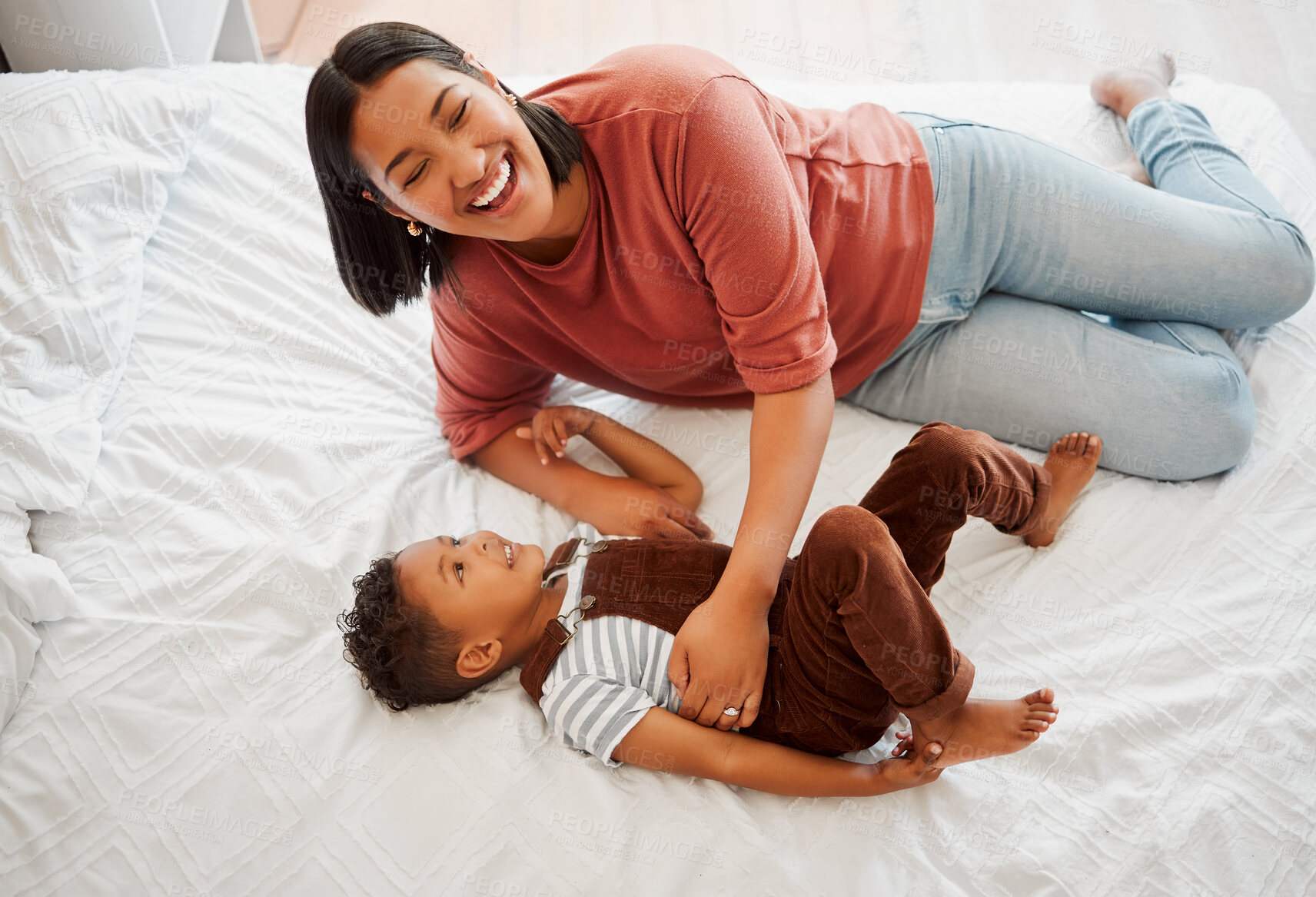 Buy stock photo Mother playing, bonding and laughing with her son playful, fun and funny moments together on the bed at home. Parenting and enjoying quality, happy single mom and her child in kids bedroom. 