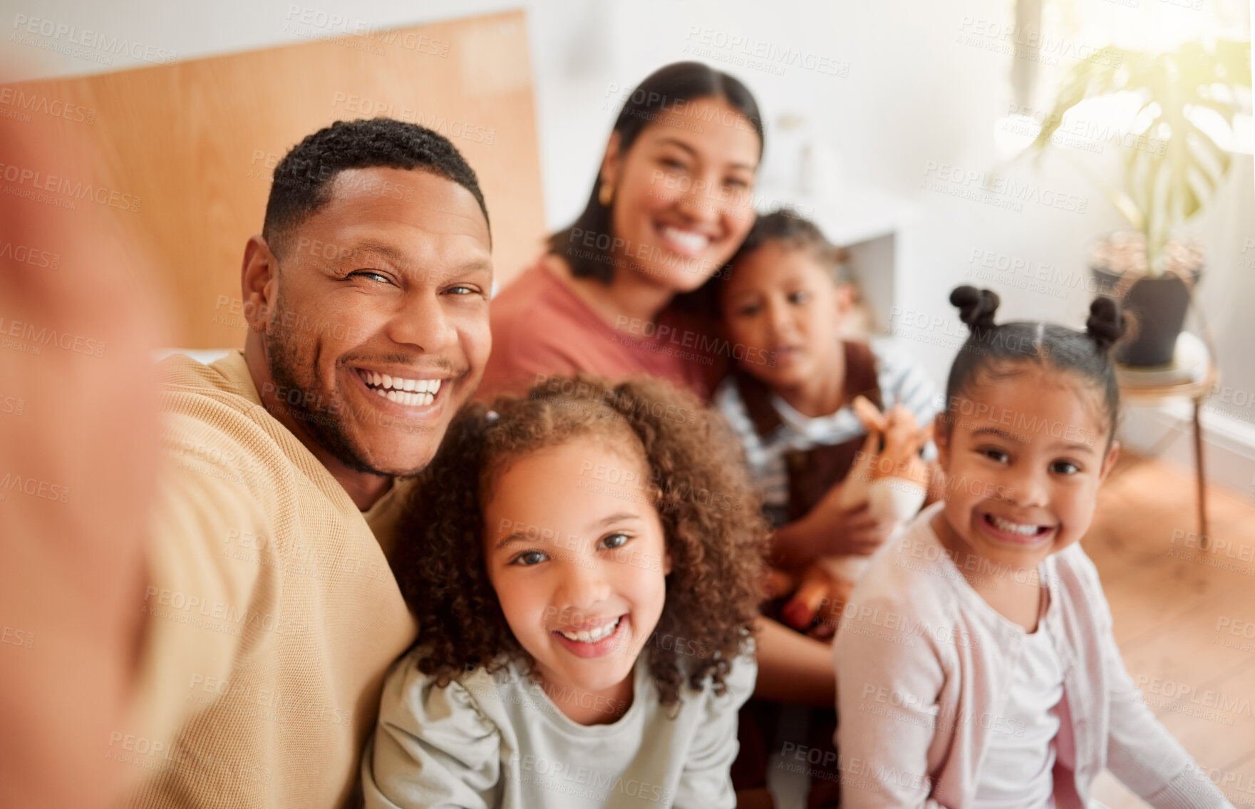 Buy stock photo Happy family taking selfie, having fun, relaxing and bonding in living room at home. Smiling, carefree parents enjoying time with children indoors, being affectionate and together on the weekend