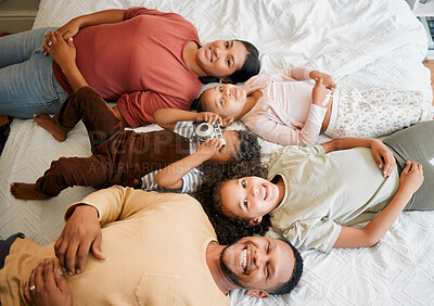 Buy stock photo Fun family, children and parents bonding while lying on a bed in home bedroom from above. Portrait of playful, smiling and happy kids having fun with mother and father on weekend and making memories