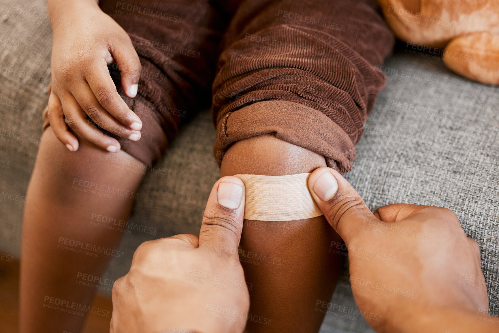 Buy stock photo Parent childcare, knee injury and plaster on child leg after getting hurt showing care, love and support to help growth and childhood development. Hands closeup of adult applying bandage to kid