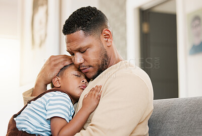 Buy stock photo Sleeping and tired child with caring father holding his sleepy son on a home lounge sofa. Worried dad hugging his young boy resting on a living room family couch indoors feeling stress and worry