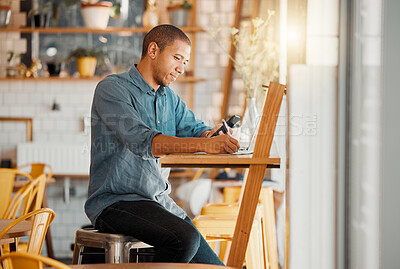 Buy stock photo Business owner, cafe manager or entrepreneur writing notes, busy on phone and working on laptop in his startup. Young male looking looking satisfied or pleased while managing finance and capital.