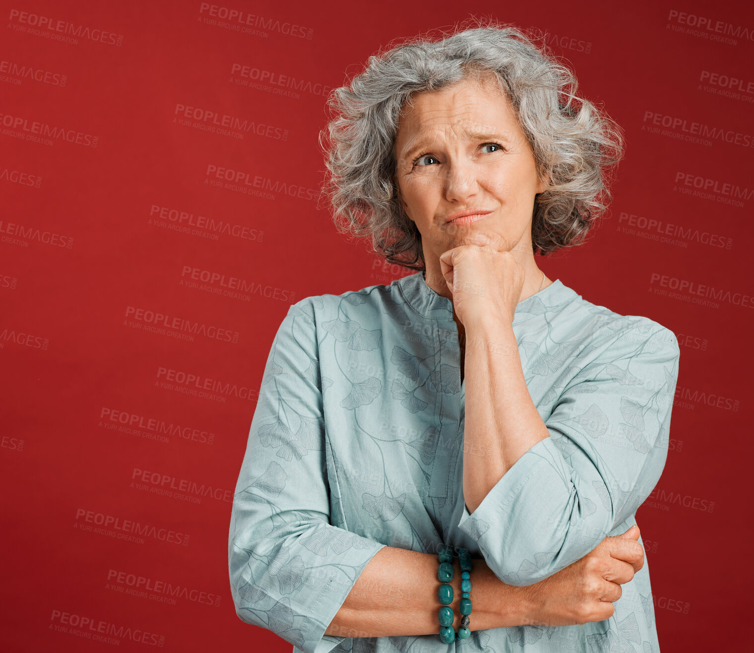 Buy stock photo Thinking, confused and wondering woman looking puzzled, unsure and uncertain about choice, decision and idea in mind against studio red background. Thoughtful senior woman with goofy frown expression