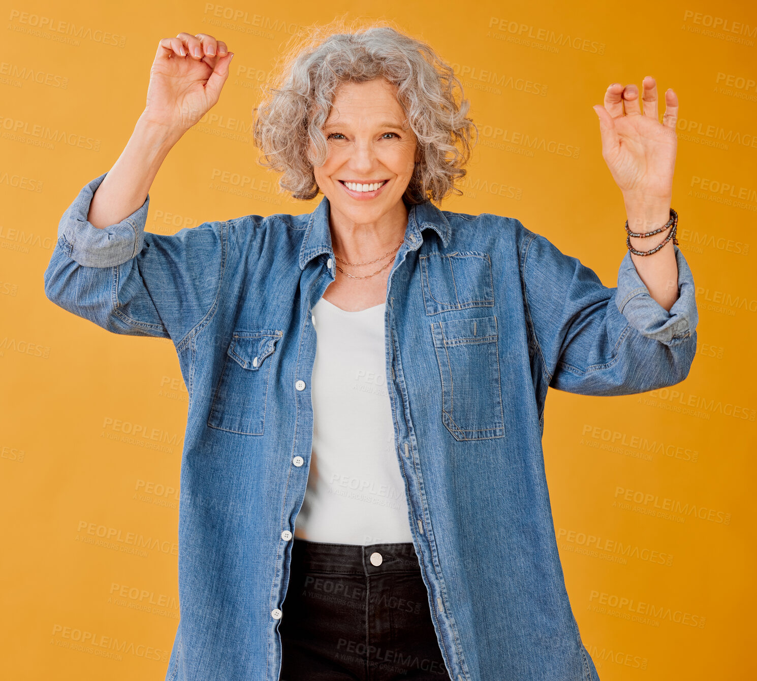 Buy stock photo Trendy, funky and fun mature female celebrate freedom against orange background, happy and carefree. Positive senior woman do victory dance, excited for retirement. Hippie free spirit lady having fun