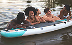 Friends, swimming and summer break with paddle board in a lake, ocean or sea over holiday, vacation or weekend. Diverse group of men and women bonding together, having fun and being playful or social