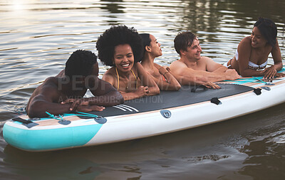 Buy stock photo Friends, swimming and summer break with paddle board in a lake, ocean or sea over holiday, vacation or weekend. Diverse group of men and women bonding together, having fun and being playful or social