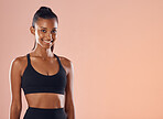 Fitness, active and healthy female athlete happy, smile and wellness studio background. Portrait of fit sport model smiling, confident and slim after training, exercise and workout with a strong body