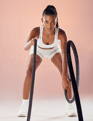 Buy stock photo Exercise, fitness goals and active woman exercising with heavy battle ropes in a studio. Portrait of a serious and athletic female working out and doing weight training for a healthy and fit body