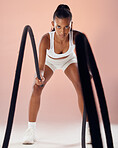 Fitness studio, exercise and healthy woman doing battle ropes workout in her training routine indoors. Girl, female and athlete in motion doing a high performance cardio for muscular strength action