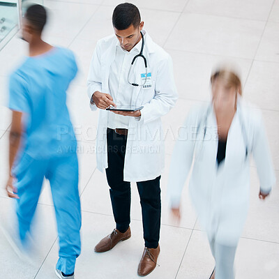 Buy stock photo Busy hospital with doctor browsing on tablet for test results, patient records and medical research from above. Healthcare professional and expert working on treatment plan in a bustling clinic