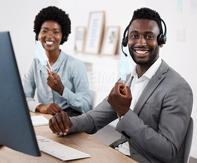 Buy stock photo Customer service agents working on computer, helping people online and giving support while sitting together at work. Portrait of smiling African call center agents removing face at end of pandemic