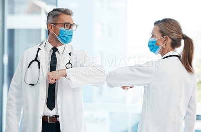 Buy stock photo Doctors doing covid safe greeting with elbow, wearing face mask to protect from virus and working in a hospital. Heathcare workers talking at a clinic, prevent spread of disease and showing support