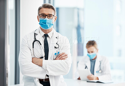 Buy stock photo Doctor, physician or healthcare professional with covid face mask in a hospital for medical health insurance background. Innovation, leadership and excellence male gp portrait with his arms crossed