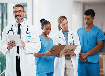 Buy stock photo Portrait of a happy leader in a group of doctors and nurses planning surgery at the hospital. Medical team or healthcare professionals reading paperwork in a meeting talking and having a discussion. 