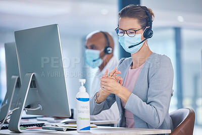 Buy stock photo Covid, hand sanitizer and call center agent with mask cleaning hands, protecting or staying safe in customer support office. Receptionist, advisor or operator with computer preventing spread of virus