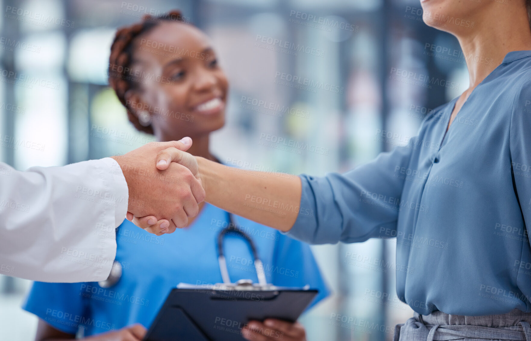 Buy stock photo Doctors handshake thank you, greeting or good medical breakthrough success with smiling nurse in background. Physician, healthcare worker and patient shaking hands for innovation in health research