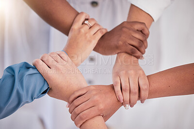 Buy stock photo Diverse colleagues hands holding wrists from above in support of unity, loyalty and teamwork in the workplace. Professional business synergy, trust and collaboration working towards strategy goal. 