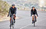 Cycling, couple goals and fitness while riding bicycles a countryside road for health and exercise. Happy male and female cyclists and athletes looking happy while training for a sports race or hobby