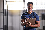 Gym, workout and personal trainer with clipboard consulting a training sports client in gym. Portrait of muscular, active and smiling fitness coach writing on health, wellness and exercise with flare