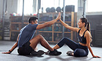 Female high five with her personal trainer or coach in the gym. Active fit woman training fitness, strength and stamina with her friend in a health center. Athletic lady and man celebrate achievment