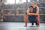 Fitness couple having fun while man does push ups and exercise together at the gym. Healthy, fit and athletic friends laugh and smile while enjoying a training session with teamwork at a health club