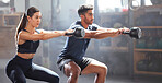 Slim, fit and gym couple exercising with dumbbell equipment, doing lower body core workout or training in a wellness facility. Young woman and man doing squatting exercise for perfect form or health