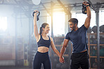 Fitness, kettlebell and couple in a workout exercise and holding hands in a gym. Fit sports people in a relationship with a strong grip, exercising with weight equipment to build muscle together. 