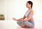 Yoga, health and wellness woman doing lotus pose exercise and mediation inside a calming studio with background and copy space. Spiritual and fit yogi woman on mat practicing inner healing and peace