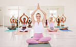 Yoga class, group training and meditation exercise in a female fitness studio. Portrait of a calm, relaxed and smiling yogi leading a peaceful training, healthy workout and mindful wellness lesson