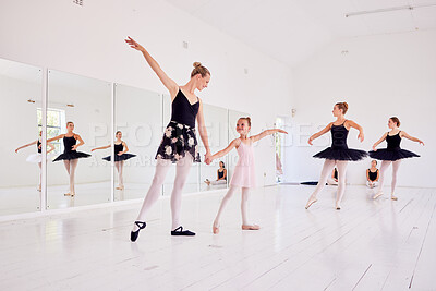 Buy stock photo Ballet instructor or teacher teaching a young dancer in a class or dance studio preparing her for a performance. Young little girl learning to be a ballerina getting training for a coach